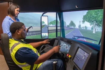 Staff at the center help with truck driving training in the simulator